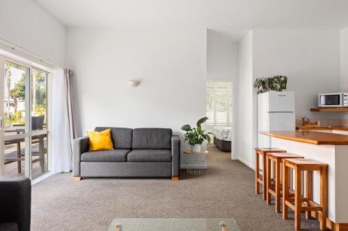 a living room with a couch and a kitchen at Ocean Beach Wainui in Gisborne