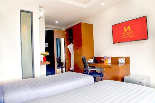 a hotel room with a bed and a desk with a computer at Swiss-Belinn Nairobi in Nairobi