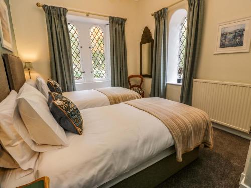 two beds in a room with two windows at East Lodge - Crathes Castle in Banchory