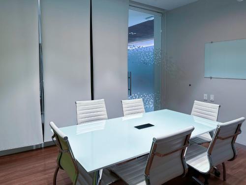 a conference room with a white table and chairs at Holiday Inn Express Mérida by IHG in Mérida