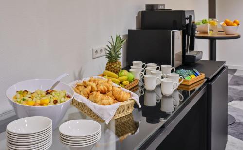 a breakfast buffet with fruit and pastries on a counter at Holiday Inn Express Frankfurt Airport by IHG in Mörfelden-Walldorf
