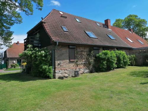 an old brick house with bushes in the yard at Ferienhaus bei der Müritz-Elde Wasserstraße in Malchow