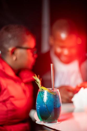 a man sitting at a table with a blue drink at Swiss-Belinn Nairobi in Nairobi