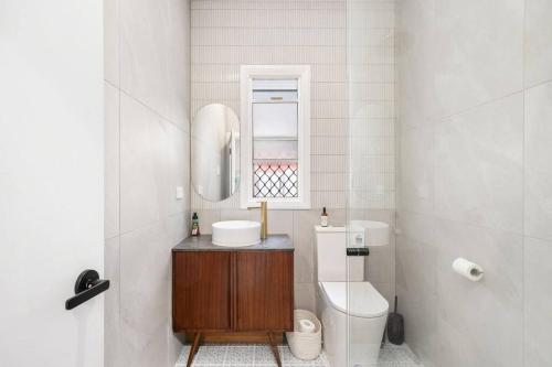 a bathroom with a sink and a toilet and a mirror at Cosy Cottage - Scarborough Beach in Scarborough