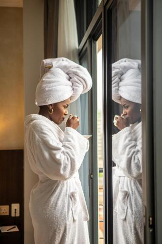 a woman in white towels looking in a mirror at Swiss-Belinn Nairobi in Nairobi
