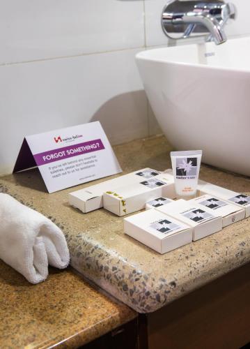a group of books sitting on a counter next to a sink at Swiss-Belinn Nairobi in Nairobi