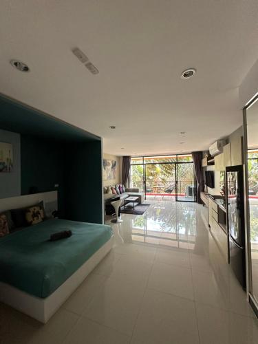 a bedroom with a green bed and a living room at Nai Harn Beach Condo (C2) in Rawai Beach