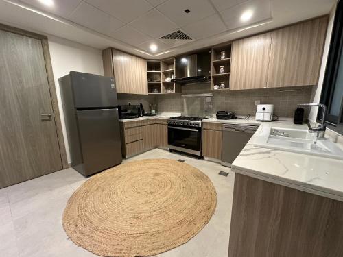 a large kitchen with a large rug on the floor at Ajmal Chalet in Al Ḩamrīyah