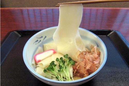 a bowl of food with noodles and vegetables in it at コウノトリの里の宿 in Fukiage