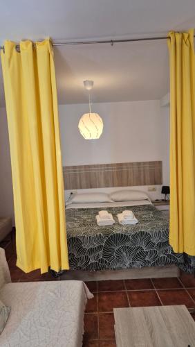 a large yellow curtain in a room with a bed at GABISOL Apartamento in Málaga