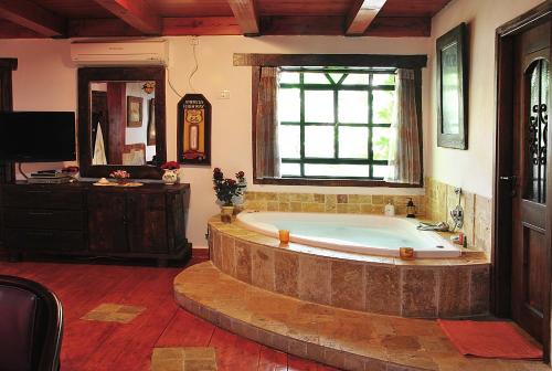 - une grande salle de bains avec une grande baignoire et une fenêtre dans l'établissement Odem Habar, à Odem