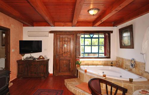 a large bathroom with a tub and a tv at Odem Habar in Odem