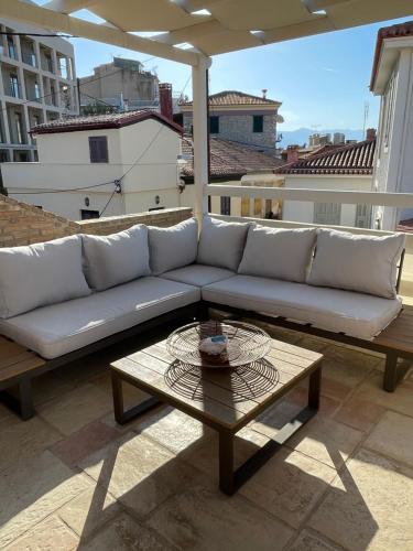 a couch and a coffee table on a balcony at Bella's Rustic Suites in Nafplio