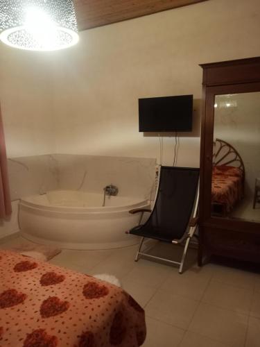 a bedroom with a tub and a chair and a bed at L'isola del relax in Vaccarizzo - Delfino