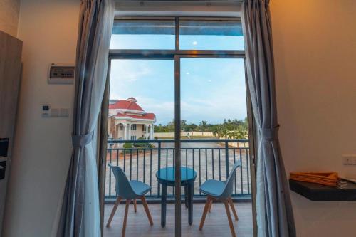 a room with a balcony with a table and chairs at Bohol Panglao Begonia Resort in Panglao