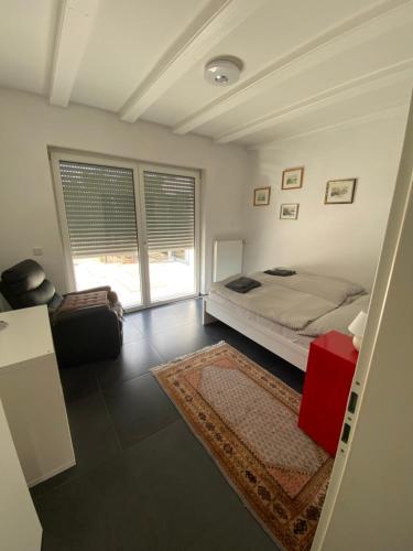 a bedroom with a bed and a chair and a window at Haus mit Garten und 2 Schlafzimmern in Neumarkt in der Oberpfalz