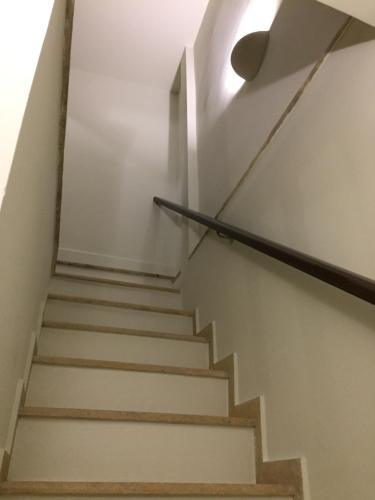 a staircase in a house with a light on the wall at Bella's Rustic Suites in Nafplio