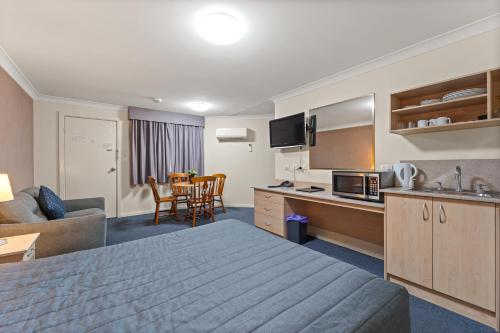 a hotel room with a bed and a living room at Golf Links Motel in Tamworth