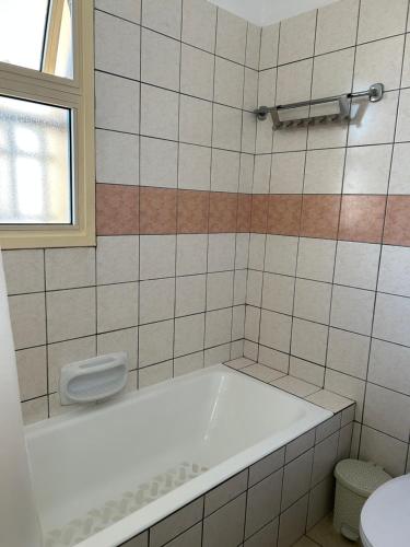 a bathroom with a bath tub and a toilet at Lovely 2 Bed Apartment Aphrodite Gardens, Paphos, Cyprus in Nea Paphos