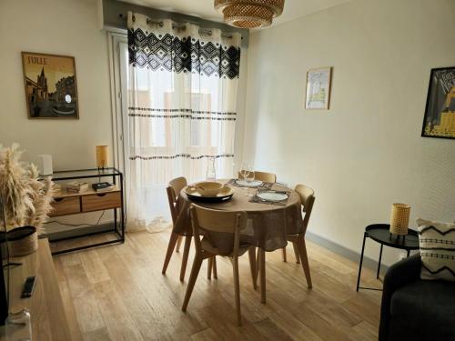 una sala da pranzo con tavolo, sedie e una finestra di La Pause Tulliste a Tulle