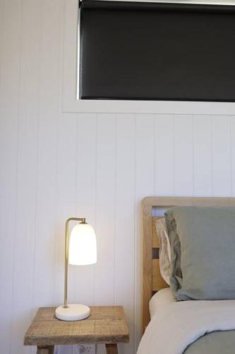 a lamp on a table next to a bed at Off-Grid Farm Stay with Scenic Views in Tenterfield
