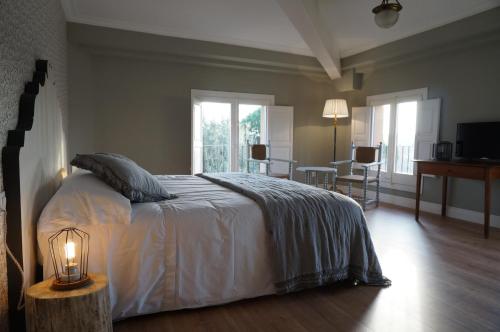 ein Schlafzimmer mit einem großen Bett mit einer Lampe und einem Tisch in der Unterkunft Hotel Can Ribalta in San Antonio de Vilamajor