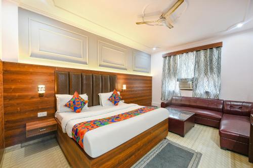 a hotel room with a bed and a couch at FabHotel Black Stone Palace in Ghaziabad