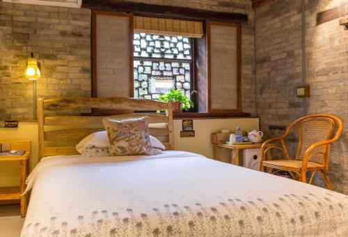 a bedroom with a large bed and a window at Governor's Mansion in Yangshuo