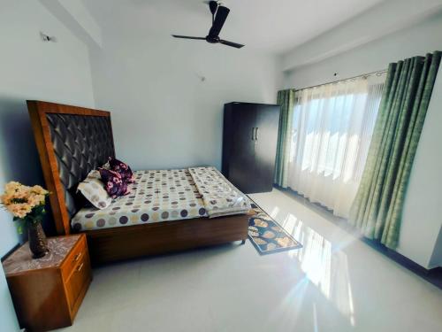 a bedroom with a bed and a window at Whispering Meadows U get entire 3 BHK in Shimla
