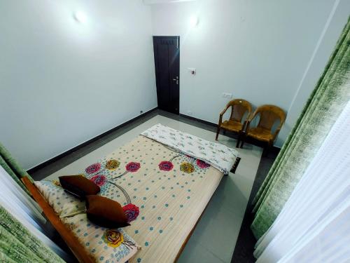 a small room with a bed and two chairs at Whispering Meadows U get entire 3 BHK in Shimla