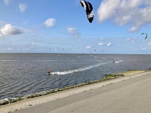 a person kite surfing in the water on the beach at Leonie 6 pers holiday home with a large garden close to the Lauwersmeer in Anjum