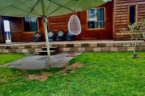 a patio with an umbrella in front of a house at Casa del árbol in Pachuca de Soto