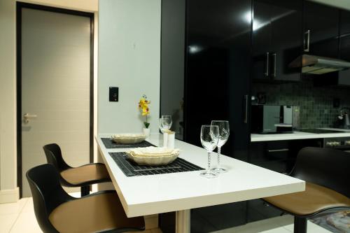 a kitchen with a white table with wine glasses at La Belle Luxury Suite Windhoek City Centre in Windhoek