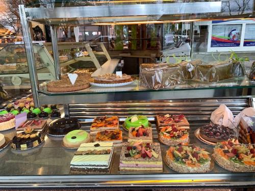 une vitrine avec de nombreux types différents de gâteaux et de tartes dans l'établissement Studio 76 - Balcon, proche Bâle, à Saint-Louis