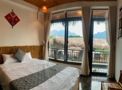 a bedroom with a bed and a large window at Mai Chau Village View in Mai Châu