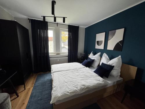 a bedroom with a large bed with blue walls at Sankt Göres Suites in Düsseldorf