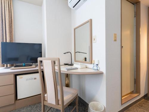 a room with a desk with a computer and a mirror at Hotel New Century in Okinawa City