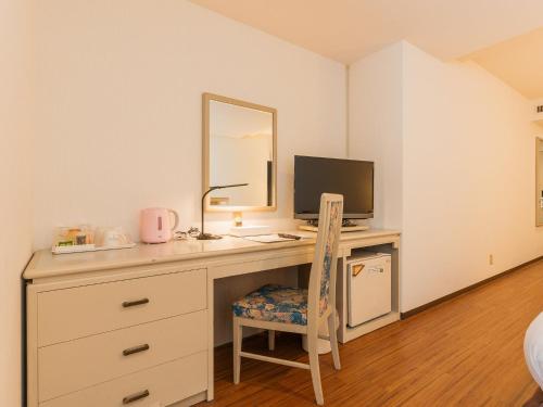 a bedroom with a desk with a computer and a mirror at Hotel New Century in Okinawa City