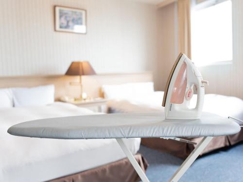 a hospital bed in a hotel room with a iron at Hotel New Century in Okinawa City