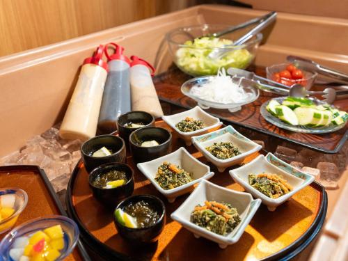 a table with a bunch of dishes of food at Hotel New Century in Okinawa City