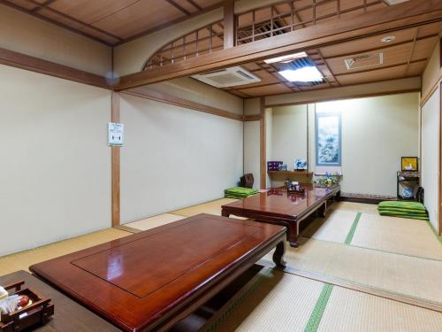 a room with a table and chairs in it at Hotel New Century in Okinawa City