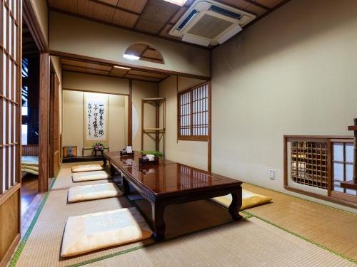 a room with a wooden table and some mats at Hotel New Century in Okinawa City