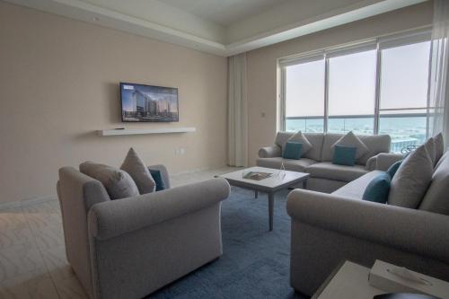 a living room with two couches and a table at Jood Hotel Apartments in Dubai