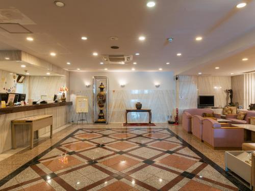a lobby with couches and a checkerboard floor at Hotel New Century in Okinawa City