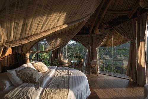 ウブドにあるBELALU Bali Boutique & SPA experienceの窓付きの部屋にベッド付きのベッドルーム1室があります。