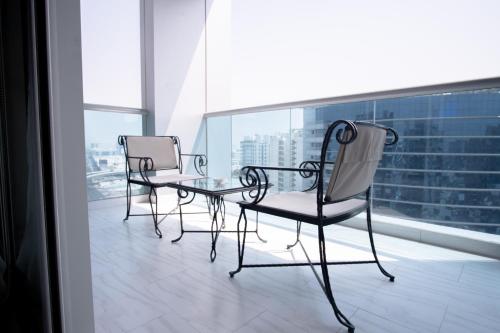 two chairs and a glass table on a balcony at Jood Hotel Apartments in Dubai