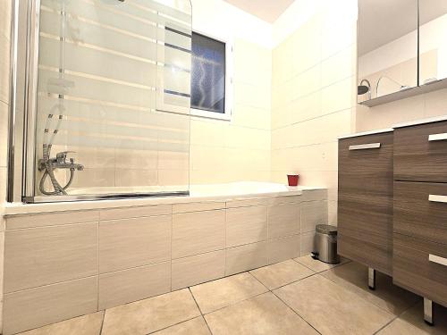 un bagno con doccia e vasca da bagno di Le Parc Jean Édouard - Spa avec jacuzzi privé - Superbe villa 4 chambres - 9 couchages - 6 lits - Poêle - Parking - Climatisation réversible- Terrasse ombragée et grand jardin a Montech