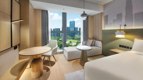 a hotel room with a bed and a table and a couch at Holiday Inn Shenzhen Nanshan by IHG in Shenzhen