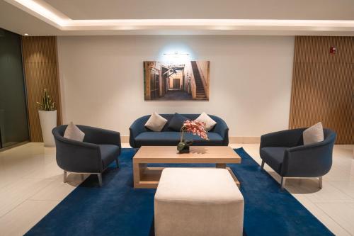 a waiting room with a couch and two chairs at Jood Hotel Apartments in Dubai