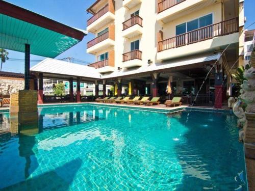 a large swimming pool in front of a hotel at Sarita Chalet Beachfront Hotel in Jomtien Beach